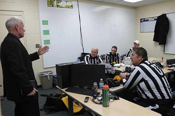 Bob Waggoner meets with the MAC officials he oversees before the Buffalo-Toledo game, two days after working Texans-Cardinals in Arizona.